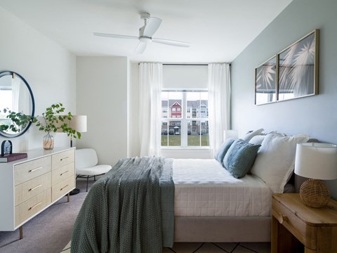 a bedroom with a bed and a large window